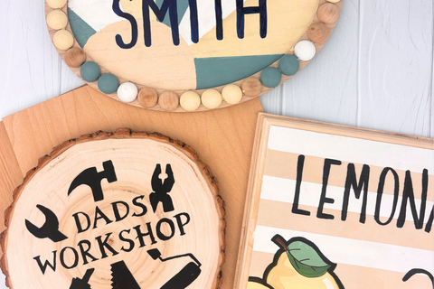 Three finished wood craft projects displayed together - a decorated keychain, ornament slice, and hexagon coaster set.