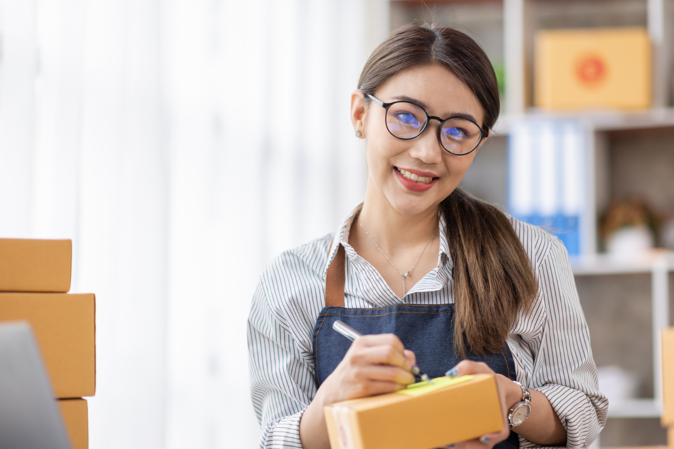 A woman writing a note for a package she is sending out.
