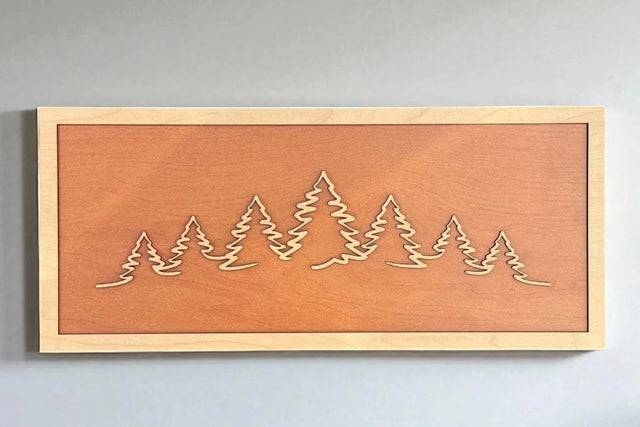 TruFlat plywood sheets in maple, walnut, cherry, and oak shown alongside laser-engraved finished pieces.