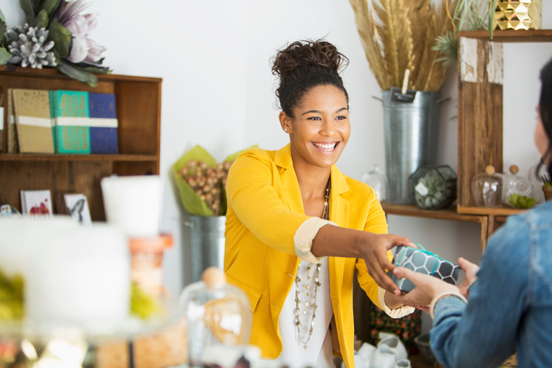 A saleswomen handing a customer her purchase. 