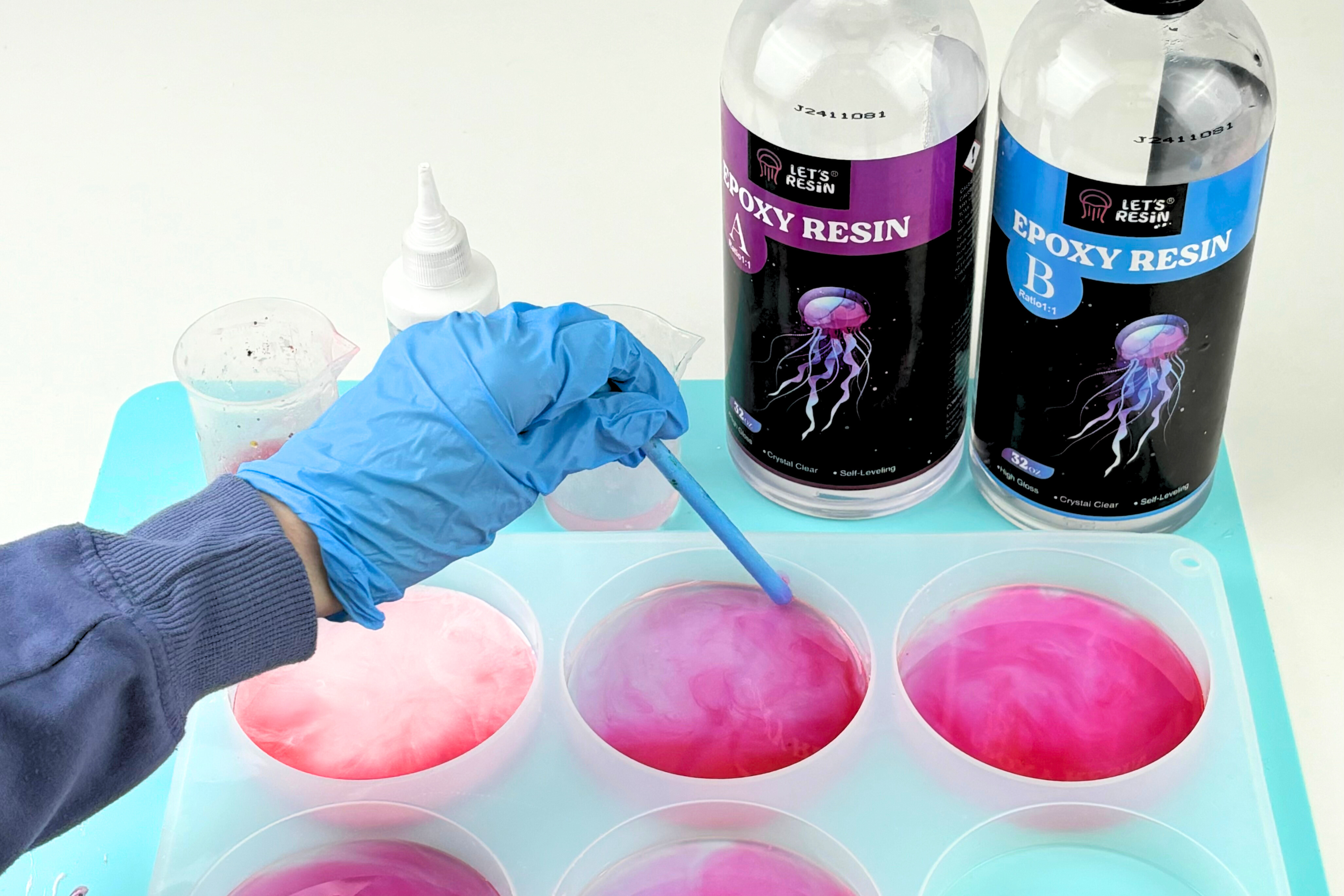 A person mixing in color pigment into resin. 