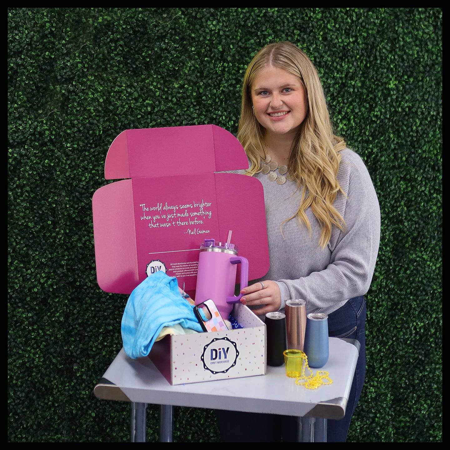 Woman with wholesale craft supplies, tumblers, vinyl, and DIY box on table, fast US shipping