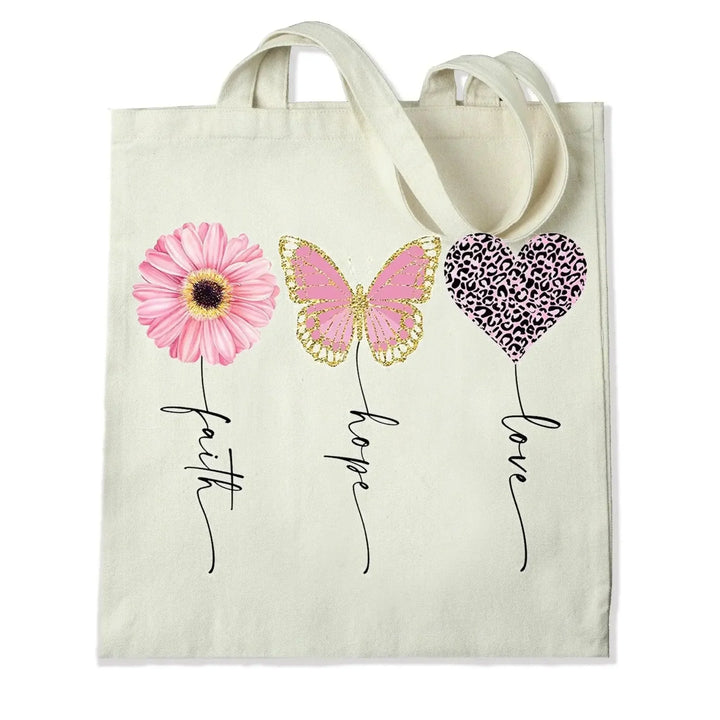 Canvas tote bag with faith, hope, love designs featuring a pink flower, butterfly, heart print.