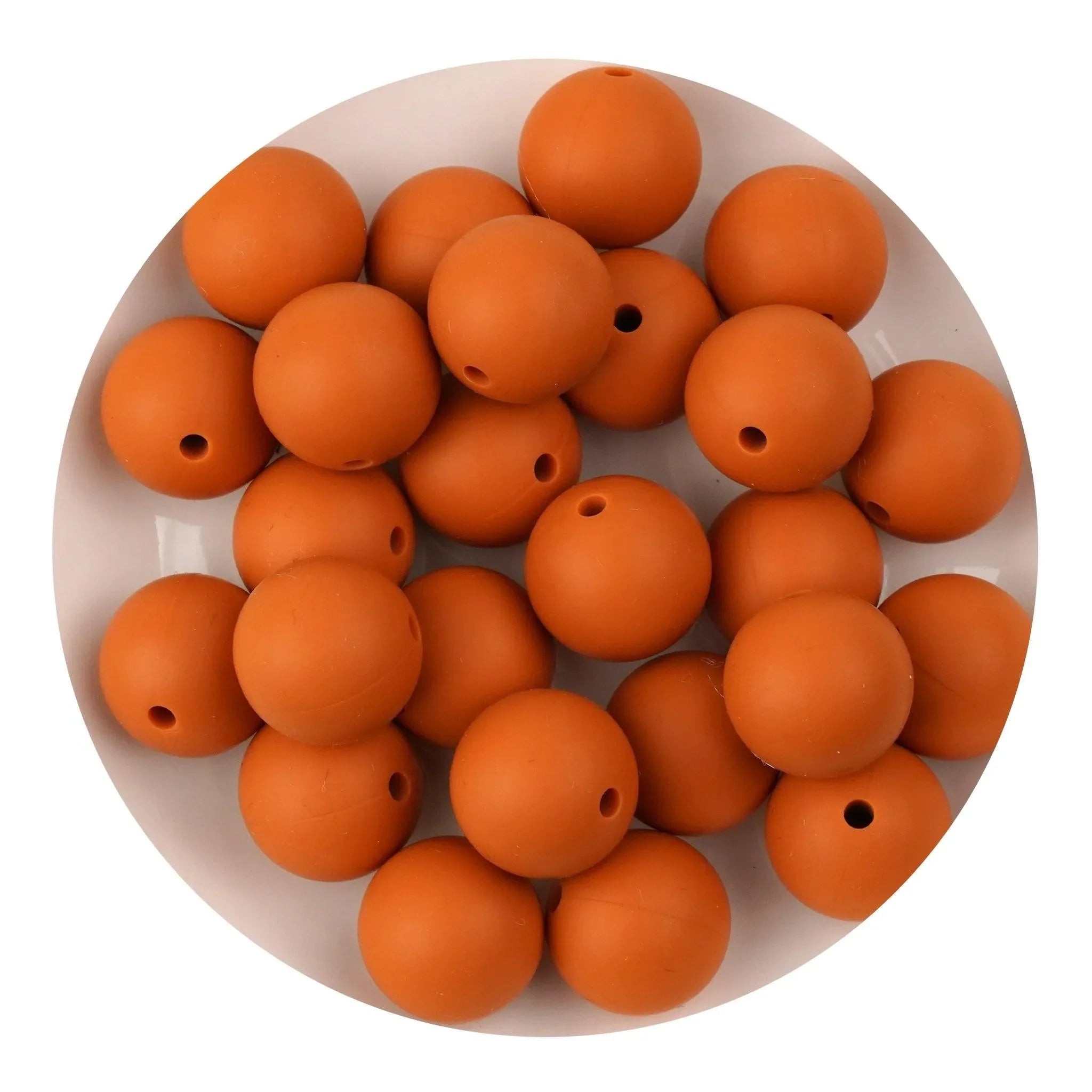 Round golden ochre silicone beads on a white plate, Master Maker Crafts wholesale supplies Ohio DIY Craft Warehouse
